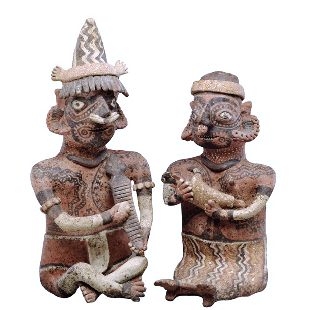 Two tiny ancient sculptures that have marks on their bodies which seem like tattoos.  